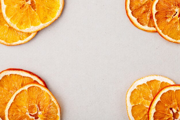 Draufsicht von getrockneten Orangenscheiben angeordnet auf weißem Hintergrund mit Kopienraum