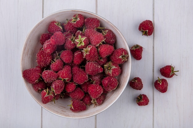 Kostenloses Foto draufsicht von himbeeren in einer schüssel auf einer weißen oberfläche