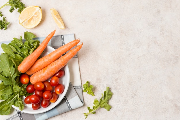 Draufsicht von Karotten und von Tomaten auf Platte