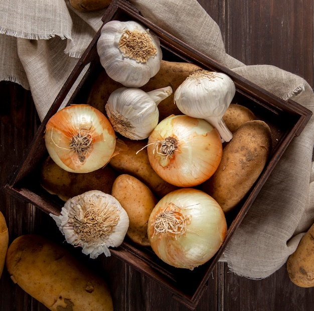 Draufsicht von Knoblauch und Zwiebeln in der Kiste