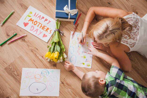 Draufsicht von Mutter und Sohn Zeichnung neben einem Muttertag Poster