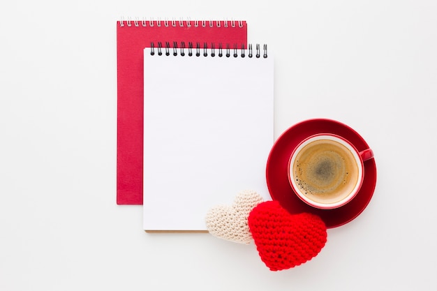 Draufsicht von Notizbüchern und von Kaffee mit Valentinstagverzierungen