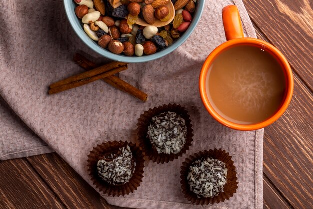 Draufsicht von Nüssen mischen Schokoladenmuffins und eine Tasse Kakaogetränk auf rustikalem