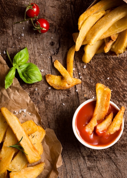 Draufsicht von Pommes Frites mit Ketchup und Kräutern