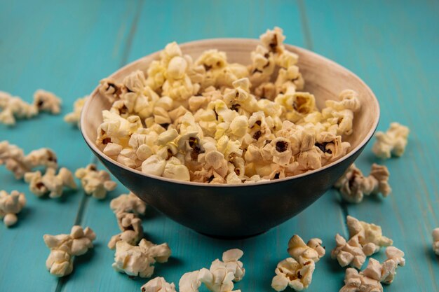 Draufsicht von Popcorn auf einer Schüssel mit Popcorn lokalisiert auf einem blauen Holztisch