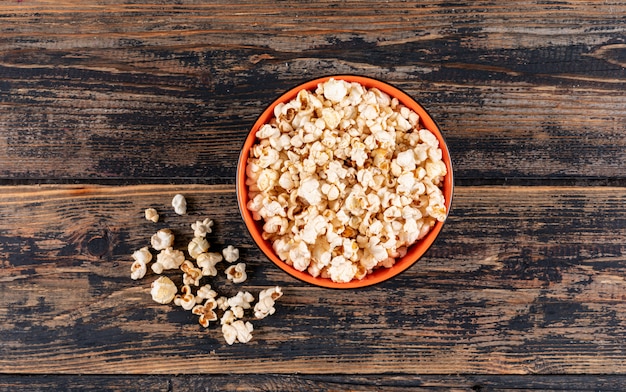 Draufsicht von Popcorn in der Schüssel auf dunklem Holz horizontal