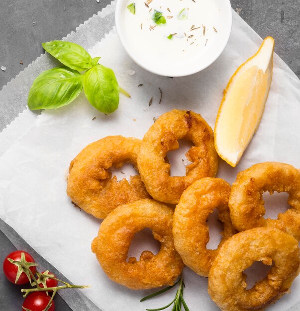 Draufsicht von Ringfritten mit Soße und Tomaten