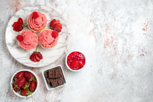 Draufsicht von rosa Erdbeerkuchen mit Marmelade auf weißer Oberfläche