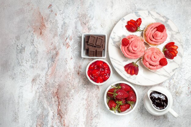 Draufsicht von rosa Erdbeerkuchen mit Marmelade auf weißer Oberfläche