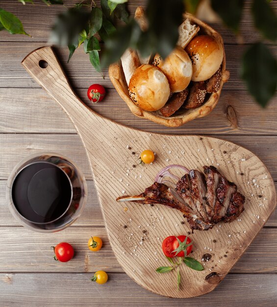 Draufsicht von Steakscheiben auf Knochen mit Meersalz besprüht, Kirschtomate