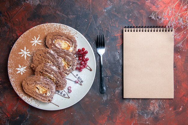 Draufsicht von süßen Keksröllchen geschnittenen cremigen Kuchen