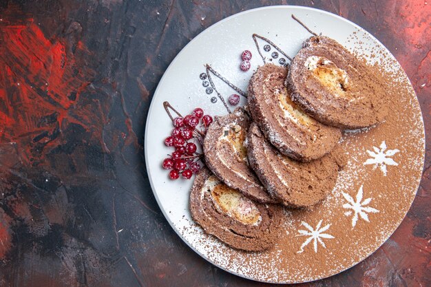 Draufsicht von süßen Keksröllchen geschnittenen cremigen Kuchen