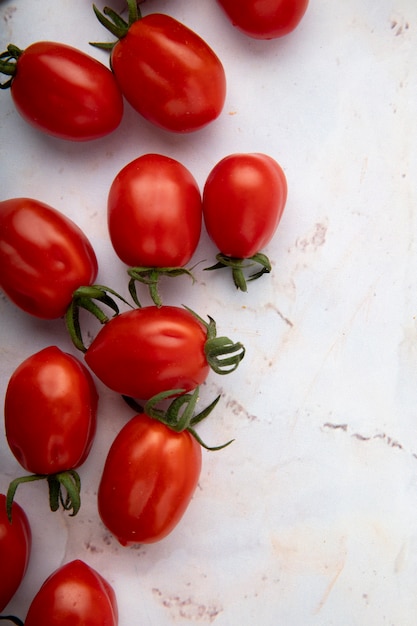 Draufsicht von Tomaten auf weißer Oberfläche auf der linken Seite