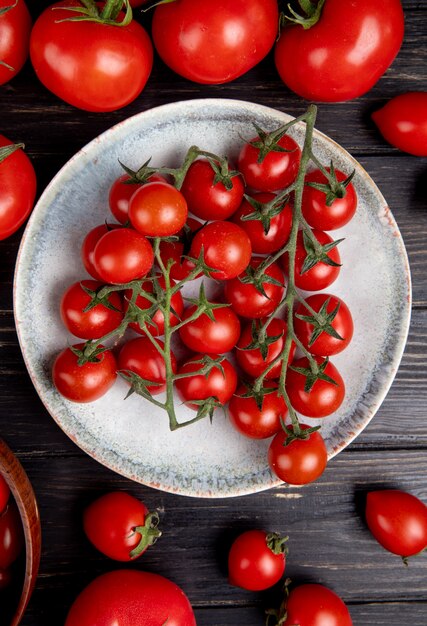 Draufsicht von Tomaten in Platte und anderen auf Holz