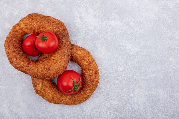 Draufsicht von türkischen Sesambagels mit frischen Tomaten auf einem weißen Hintergrund mit Kopienraum