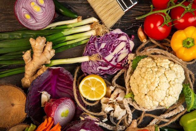 Draufsicht von verschiedenen Gemüse Rotkohl Blumenkohl Frühlingszwiebel Zitrone und Tomaten auf