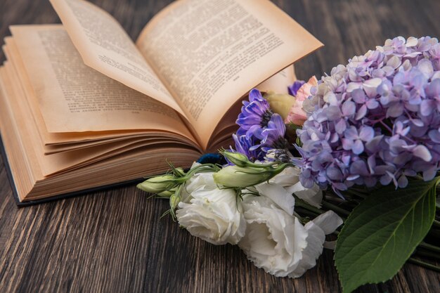 Draufsicht von verschiedenen schönen Blumen wie Fliederrosengänseblümchen auf einem hölzernen Hintergrund