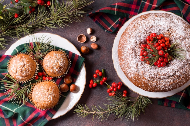 Draufsicht von Weihnachtscupcakes und -kuchen mit roten Beeren