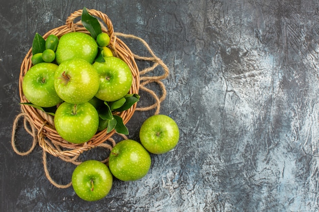 Kostenloses Foto draufsicht von weitem äpfelseilkorb der appetitlichen äpfel mit blättern zitrusfrüchten