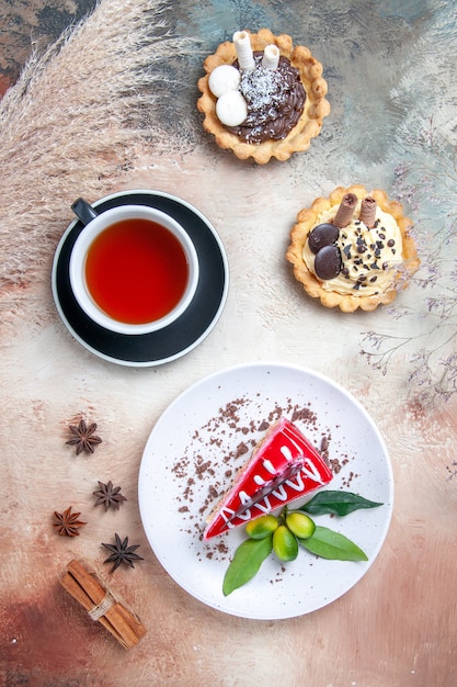 Draufsicht von weitem ein kuchen eine tasse tee ein kuchen zitrusfrüchte cupcakes zimt sternanis