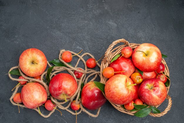 Draufsicht von weitem Äpfel die appetitlichen Apfelkirschen im Korbseil auf dem dunklen Tisch