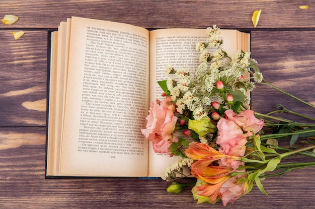 Kostenloses Foto draufsicht von wundervollen verschiedenen und bunten blumen auf einem buch