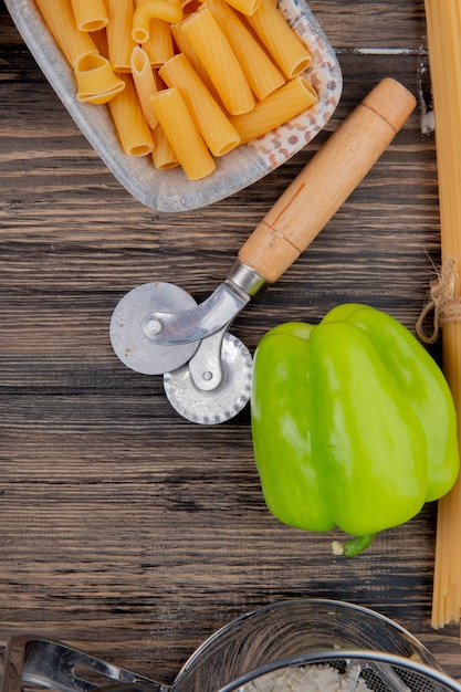 Draufsicht von Ziti-Makkaroni und Pfeffer auf Holz