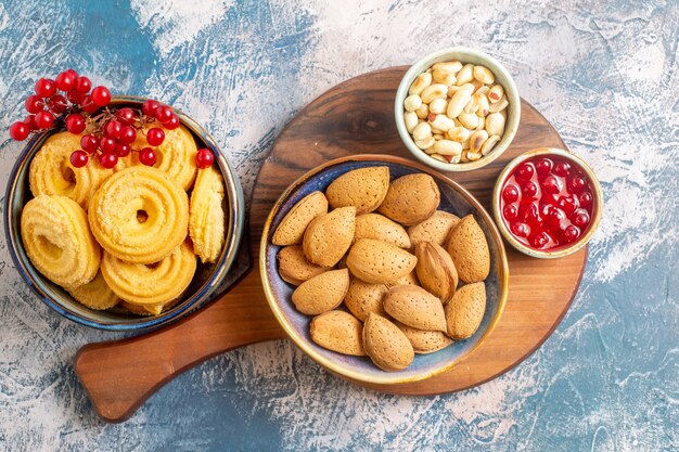 Draufsicht von Zuckerkeksen mit Nüssen und Marmelade auf heller Oberfläche