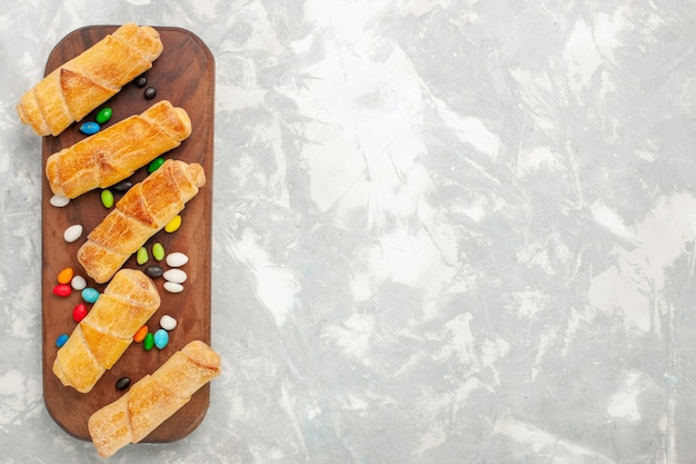 Draufsicht von zuckerpulverbagels mit bonbons auf weißem schreibtisch