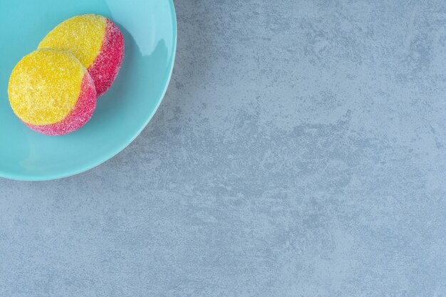 Draufsicht von zwei Pfirsichplätzchen auf blauem Teller.