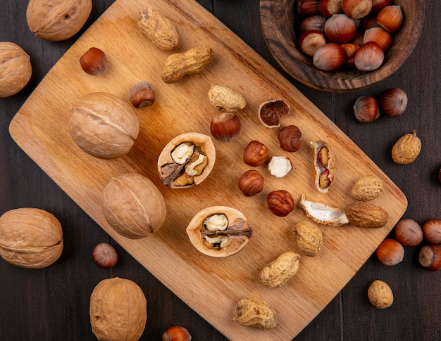 Draufsicht Walnüsse mit Haselnüssen und Erdnüssen auf einem Brett auf einem Holztisch
