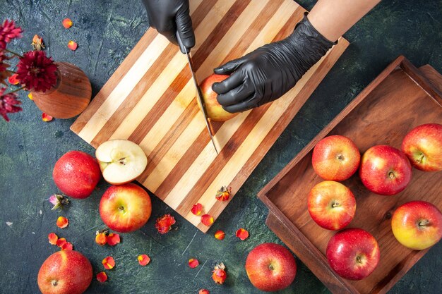Draufsicht weiblicher Koch, der Äpfel auf der grauen Oberfläche schneidet