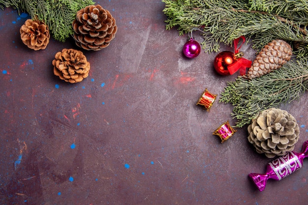 Draufsicht-Weihnachtsbaum mit Zapfen und Spielzeug auf dunklem Raum