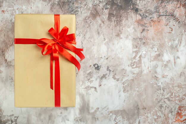 Draufsicht Weihnachtsgeschenk mit roter Schleife auf weißem Foto Urlaub Farbe Neujahr Geschenk Weihnachten freien Platz gebunden