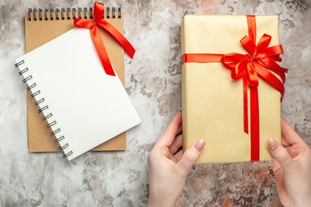 Draufsicht Weihnachtsgeschenk mit roter Schleife auf weißem Neujahrsgeschenk Foto Urlaub Farbe Weihnachten gebunden