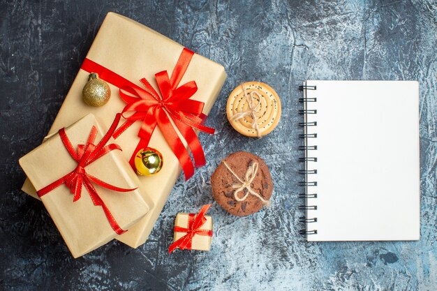 Draufsicht Weihnachtsgeschenke mit Keksen auf hell-dunklem Hintergrund