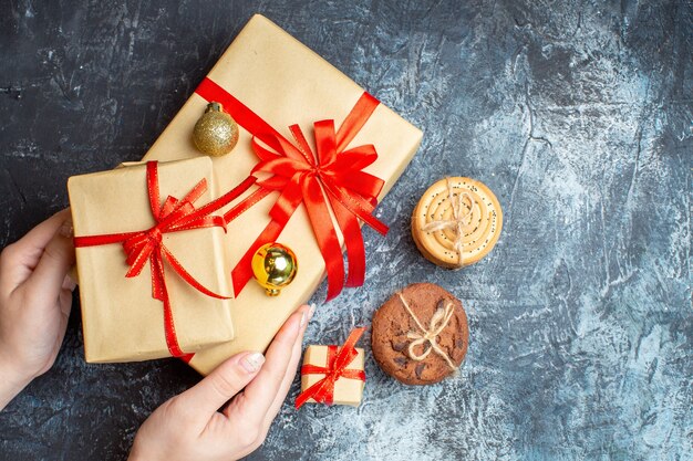 Draufsicht Weihnachtsgeschenke mit Keksen auf hell-dunklem Hintergrund