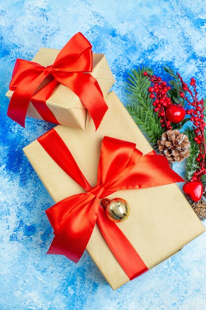 Draufsicht Weihnachtsgeschenke mit rotem Band Weihnachtsschmuck auf blau-weißem Tisch gebunden