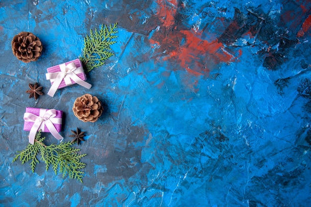 Kostenloses Foto draufsicht weihnachtsgeschenke tannenbaum zweige kegel anis auf blauem hintergrund