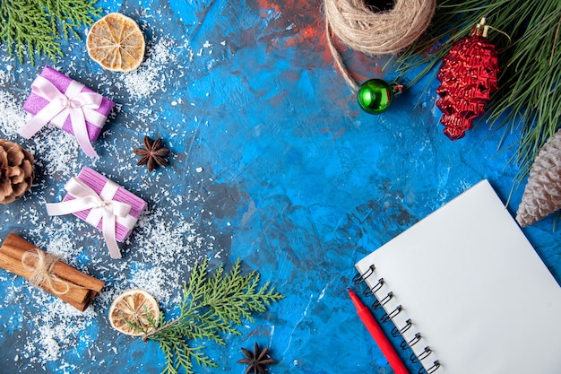 Draufsicht Weihnachtsgeschenke Tannenbaum Zweige Kegel Anis auf blauer Oberfläche