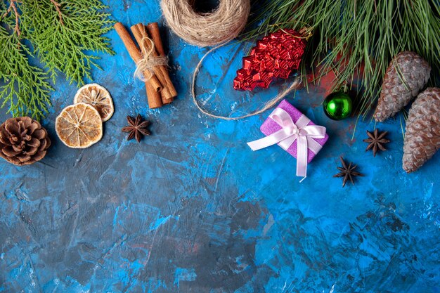 Draufsicht Weihnachtsgeschenke Tannenbaum Zweige Kegel Anis auf blauer Oberfläche