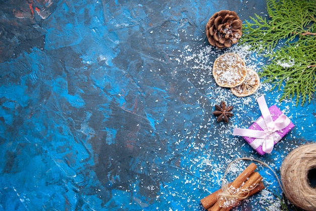 Draufsicht Weihnachtsgeschenke Tannenbaum Zweige Kegel Anis auf blauer Oberfläche