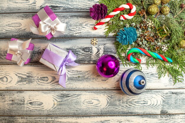 Draufsicht Weihnachtsschmuck Geschenke Süßigkeiten Tannenzweige auf Holzoberfläche