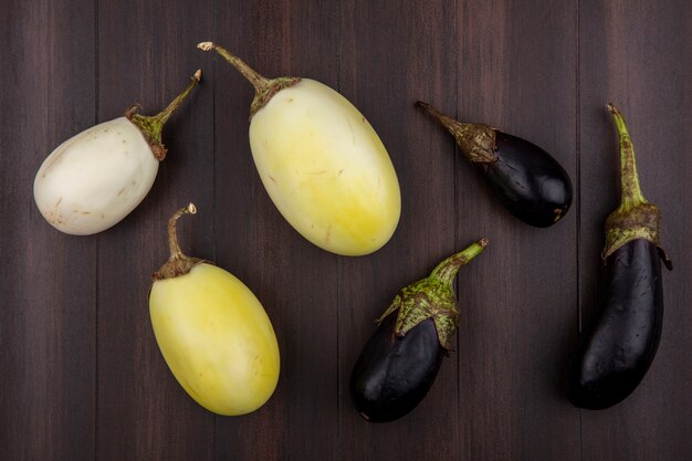 Draufsicht weiße und schwarze Aubergine auf hölzernem Hintergrund