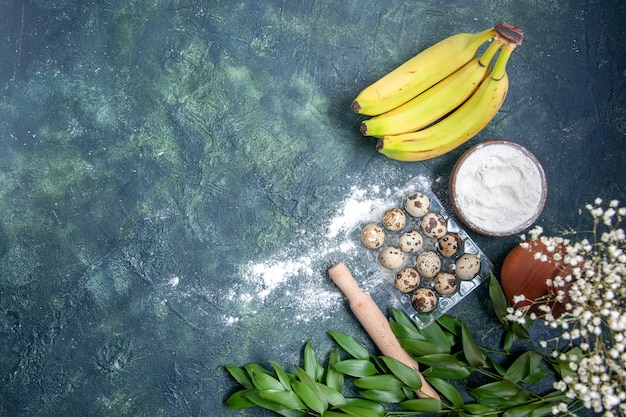 Draufsicht weißes Mehl mit Bananen und Eiern auf dunkelblauem Hintergrund Teig Lebensmittel Gebäck Ofen Kuchen Kuchen Staub backen