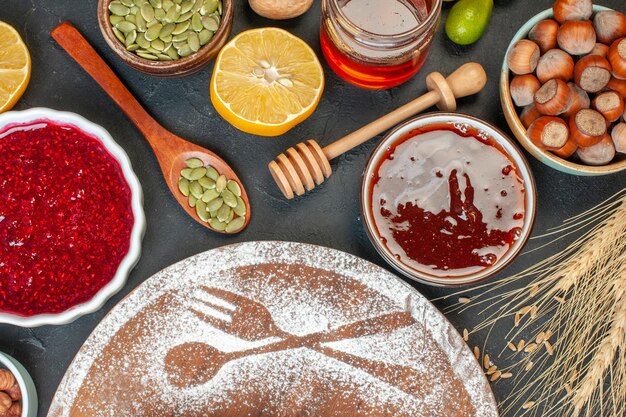 Draufsicht Weißmehl mit Nüssen Honig und Marmelade auf dunklem Kuchen Obst süße Torte Tee Dessert Keks Zuckergebäck