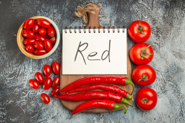 Draufsicht würzige rote Paprika mit Tomaten und roter Schrift auf dunklem Hintergrundfoto reifes Essen