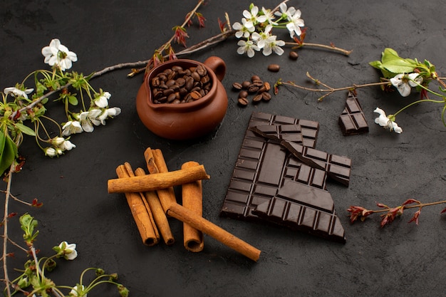 Draufsicht Zimtschokoladenkaffee zusammen mit weißen Blumen auf dem dunklen Boden