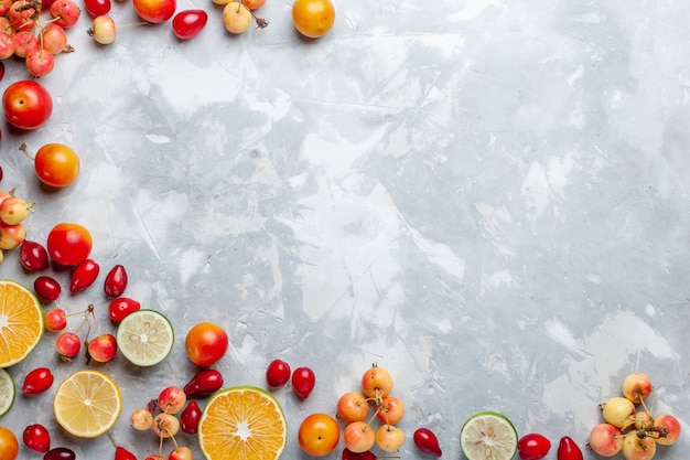 Draufsicht Zitronen und Kirschen frische Früchte auf dem hellen Schreibtisch Obst frisch weich reif