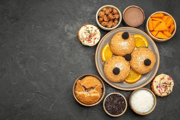 Draufsicht zuckerkekse mit orangenscheiben auf dunkler oberfläche cookie keks süßer teekuchen